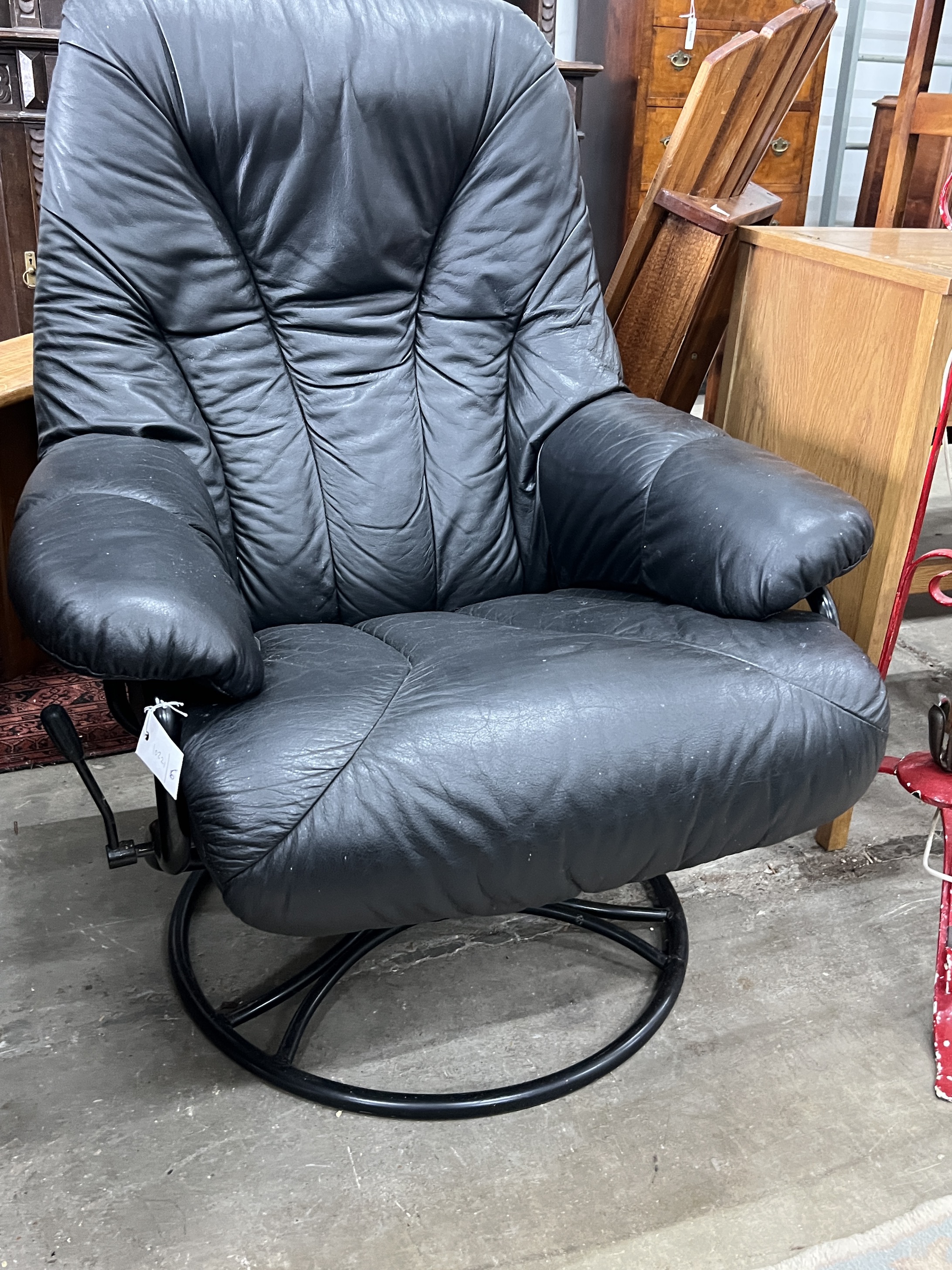 A mid century Scandinavian black leather reclining swivel armchair, width 74cm, depth 78cm, height 96cm